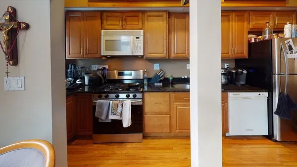 a kitchen with stainless steel appliances granite countertop a refrigerator a stove and a sink