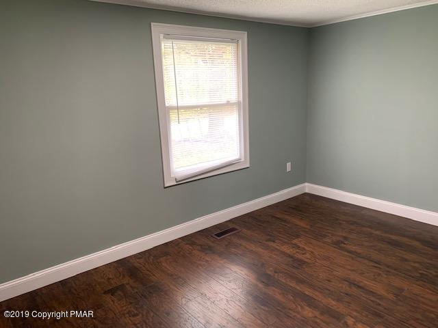 1023 Dancing Ridge Road East Stroudsburg, PA 18302 - Photo 17 of 23 an empty room with wooden floor and windows