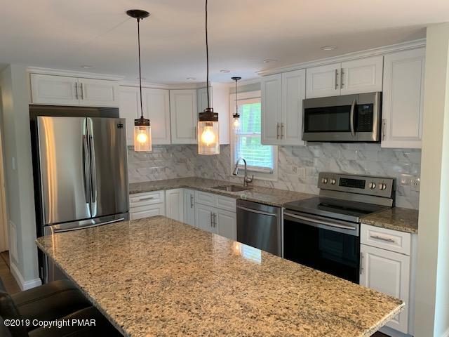 1023 Dancing Ridge Road East Stroudsburg, PA 18302 - Photo 5 of 23 a kitchen with stainless steel appliances granite countertop a sink refrigerator and microwave