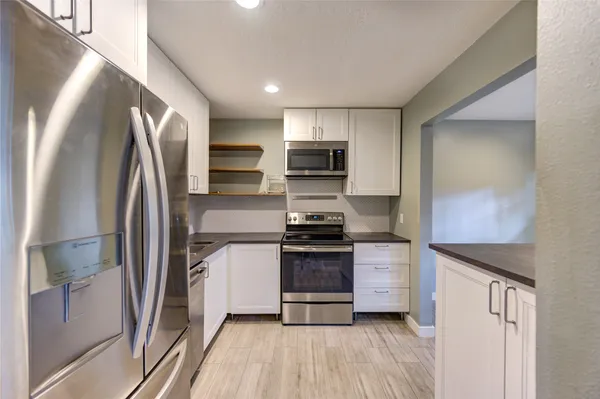a kitchen with stainless steel appliances a refrigerator sink and stove