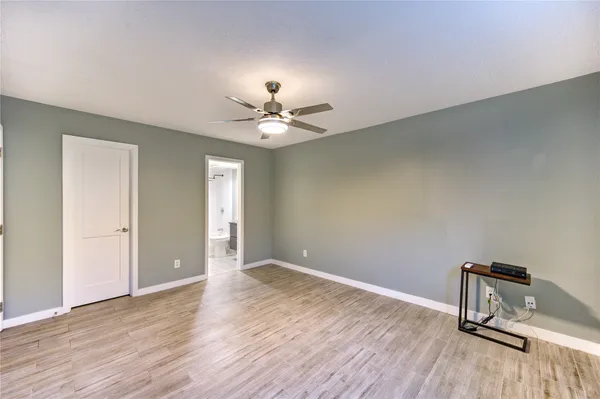 a view of room with wooden floor and ceiling fan