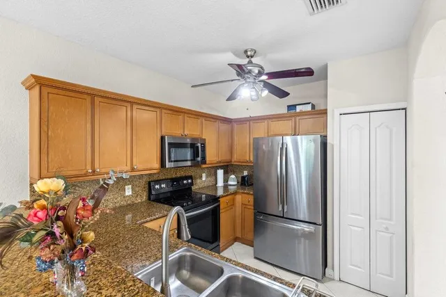 a kitchen with stainless steel appliances granite countertop a refrigerator stove and microwave