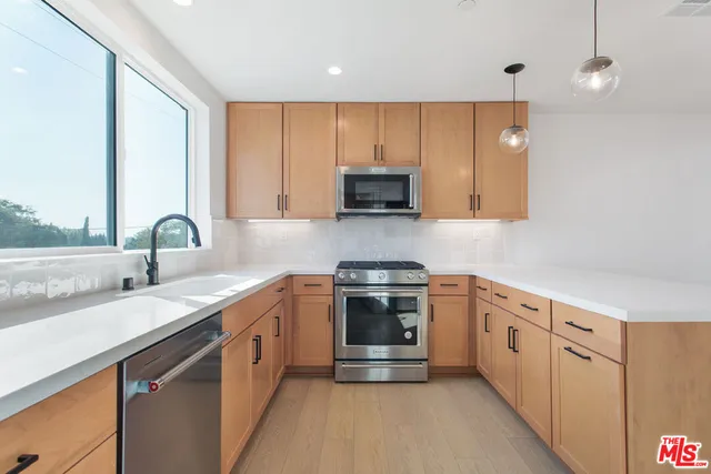 a kitchen with cabinets and a refrigerator