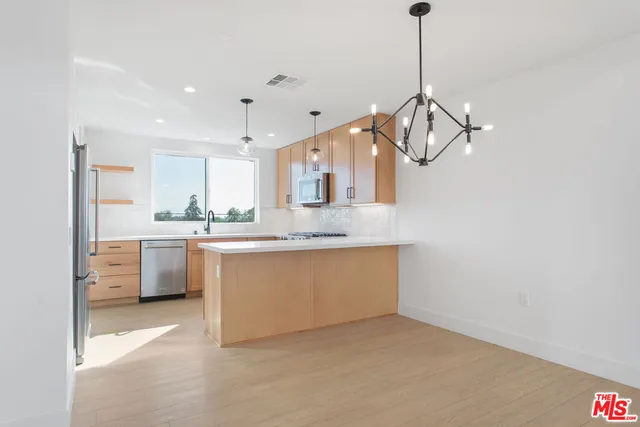 a kitchen with stainless steel appliances granite countertop a sink a stove and a refrigerator