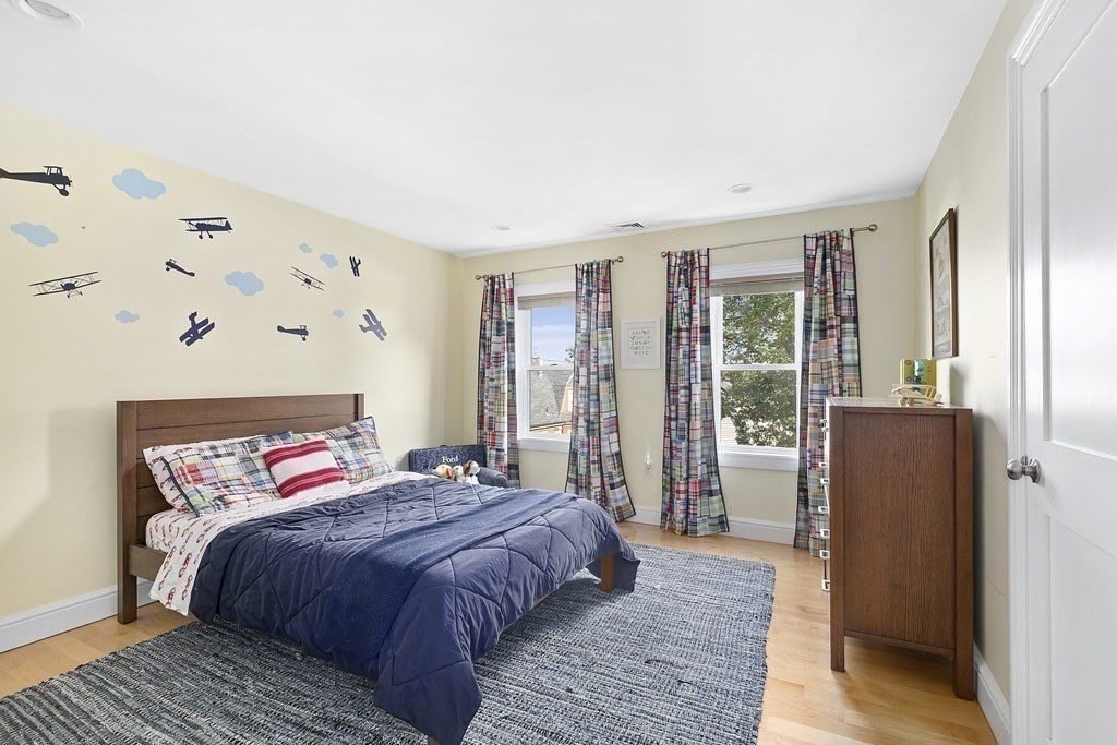 58 Liberty Avenue, Unit 2 Somerville, MA 02144 - Photo 16 of 22 a bedroom with a large bed and wooden floor