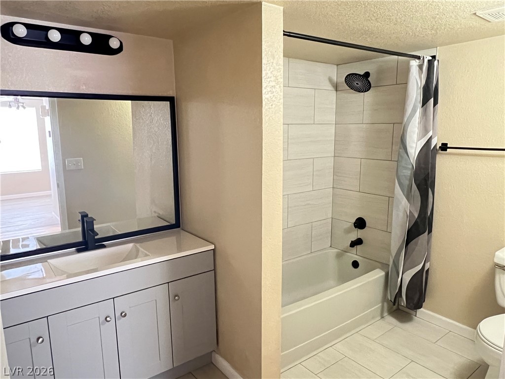 8101 West Flamingo Road, Unit 2161 Las Vegas, NV 89147 - Photo 12 of 15 Refreshed primary bath featuring a modern double vanity and a tiled shower-tub combination.