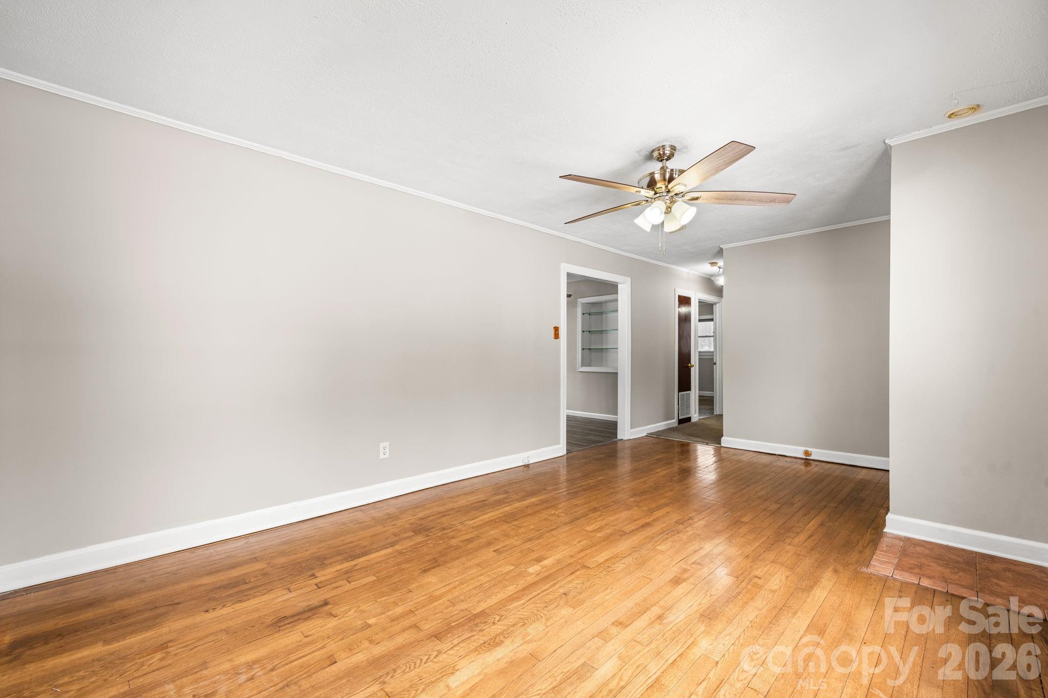 203 3rd Avenue Northeast Conover, NC 28613 - Photo 19 of 30 an empty room with wooden floor and a ceiling fan
