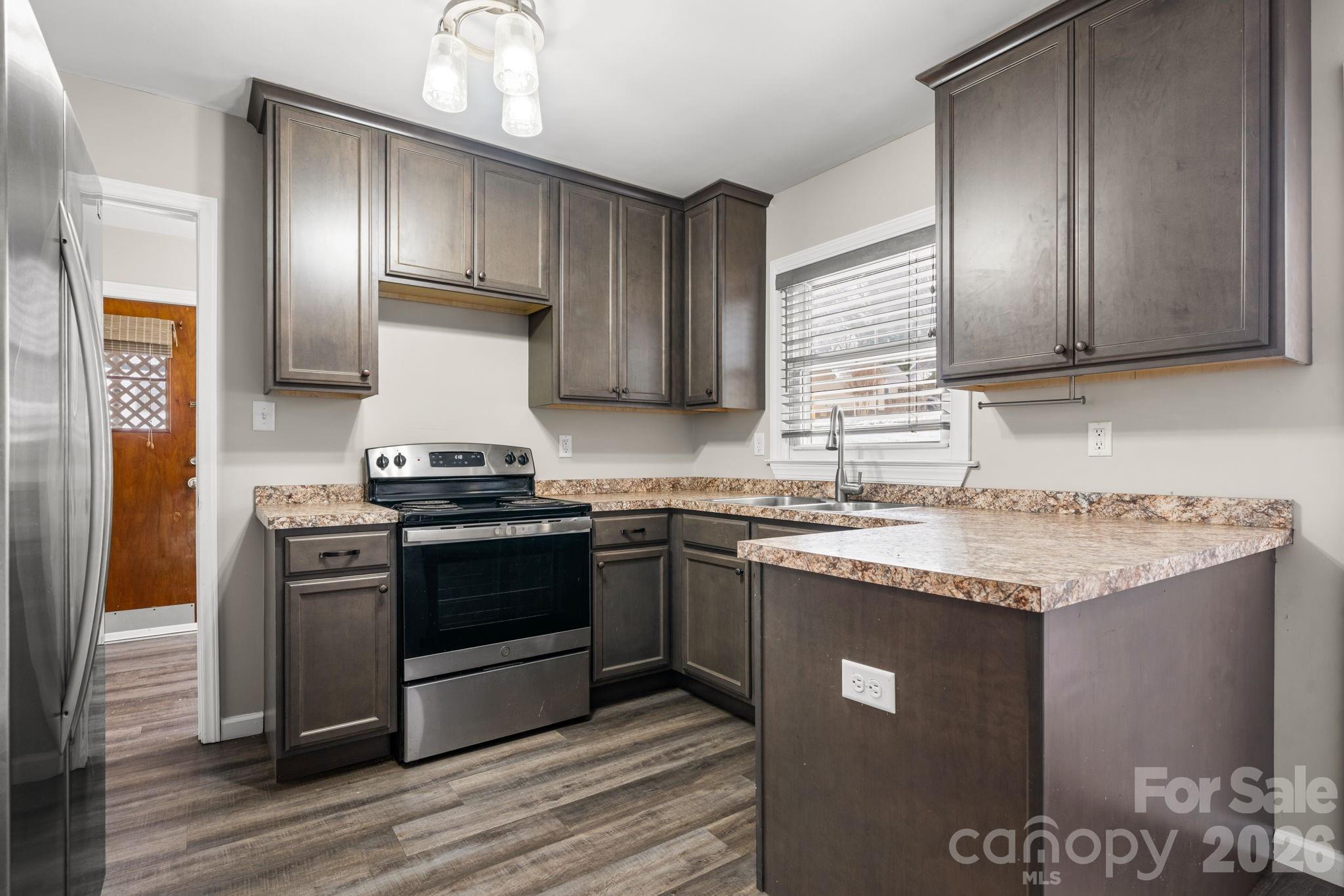 203 3rd Avenue Northeast Conover, NC 28613 - Photo 20 of 30 a kitchen with granite countertop stainless steel appliances and wooden cabinets