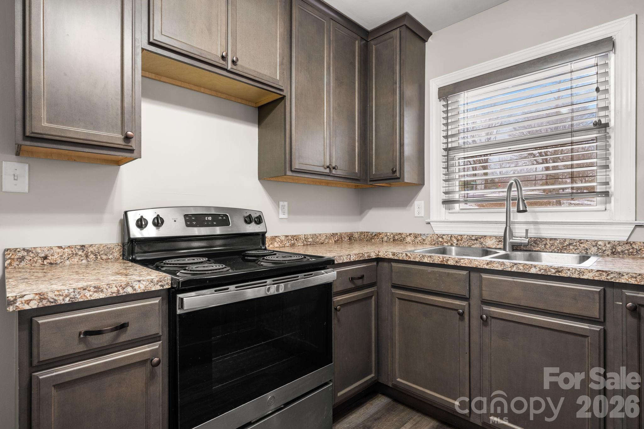 203 3rd Avenue Northeast Conover, NC 28613 - Photo 21 of 30 a kitchen with granite countertop cabinets stainless steel appliances and a sink