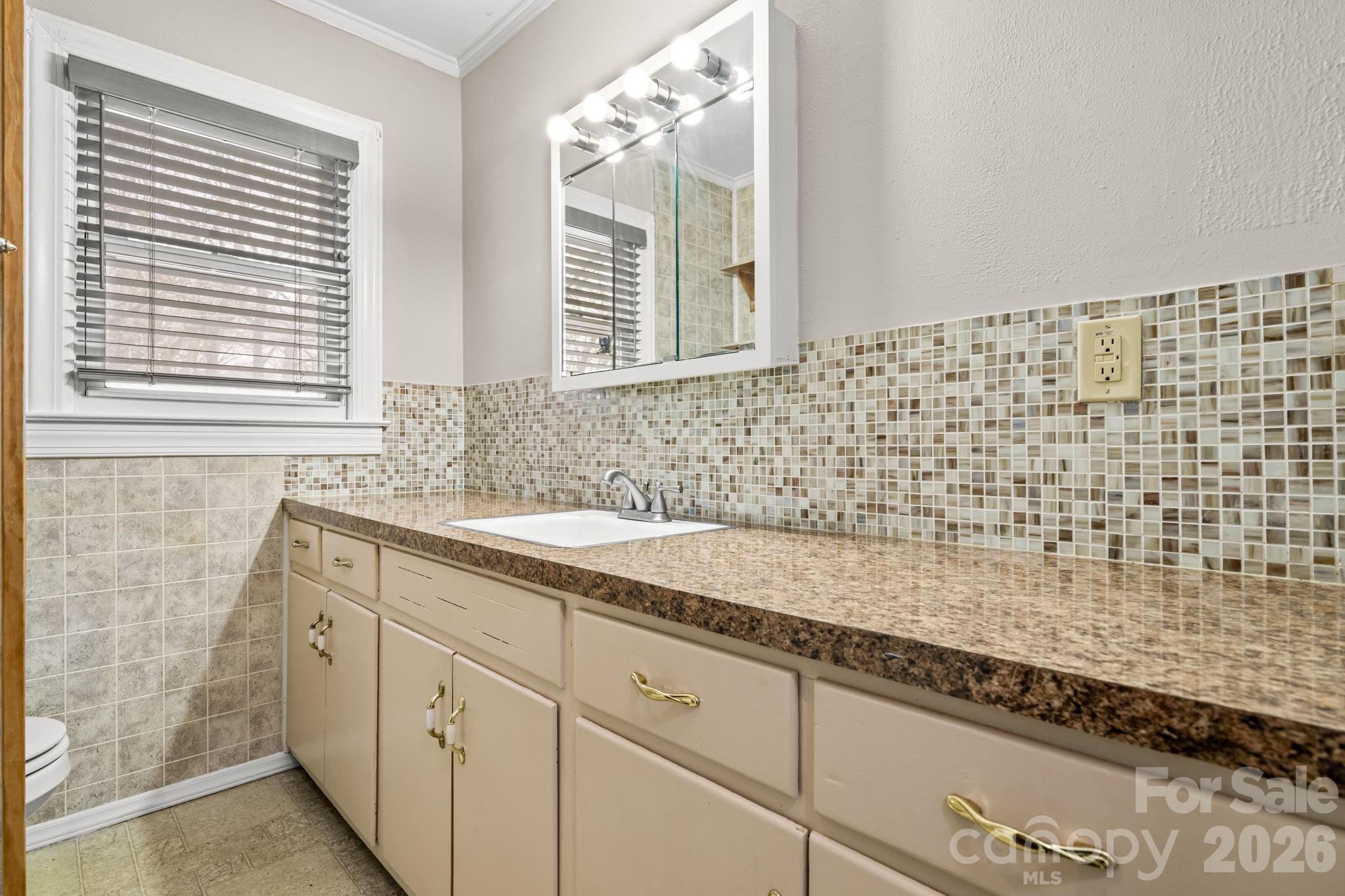 203 3rd Avenue Northeast Conover, NC 28613 - Photo 27 of 30 a bathroom with a granite countertop sink a mirror and a shower