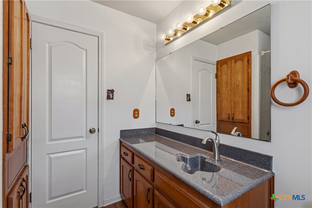 261 County Road 4963 Kempner, TX 76539 - Photo 35 of 44 a bathroom with a sink vanity granite tub and a mirror