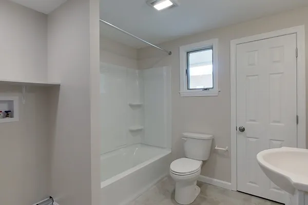 a white toilet sitting next to a bath tub