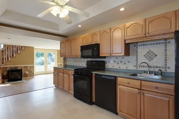 a kitchen with granite countertop a sink stainless steel appliances and cabinets
