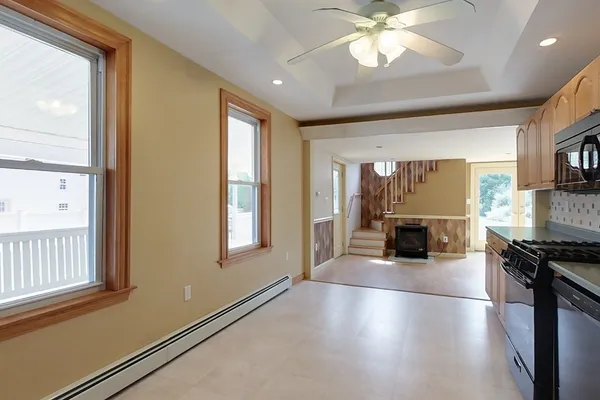 a view of a kitchen with furniture a ceiling fan and window