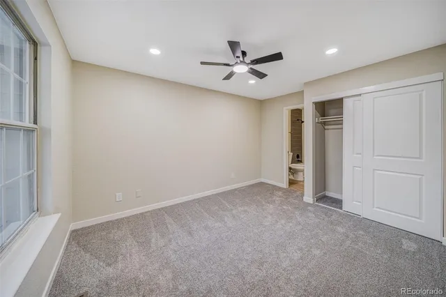 an empty room with closet and a ceiling fan