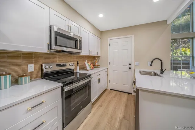 a kitchen with stainless steel appliances a stove microwave and sink