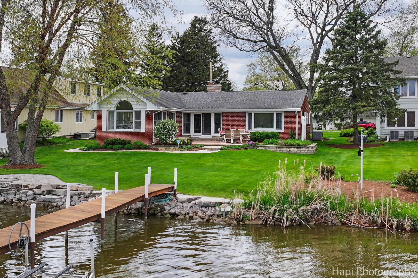a front view of a house with a yard with swimming pool and green space