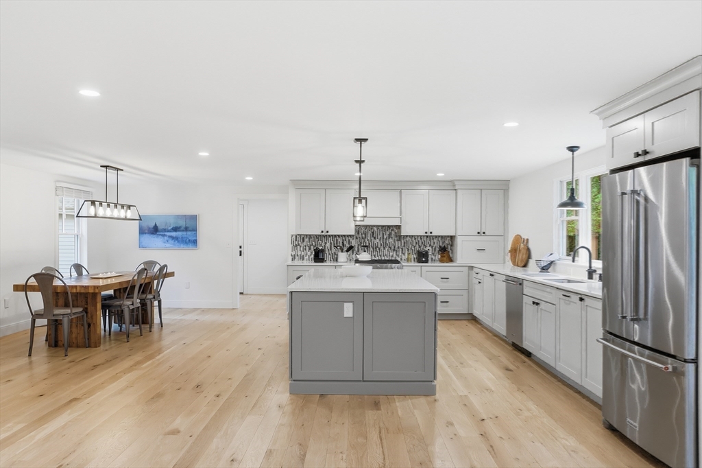 136 Holden Wood Road Concord, MA 01742 - Photo 11 of 31 a kitchen with a dining table chairs refrigerator and cabinets