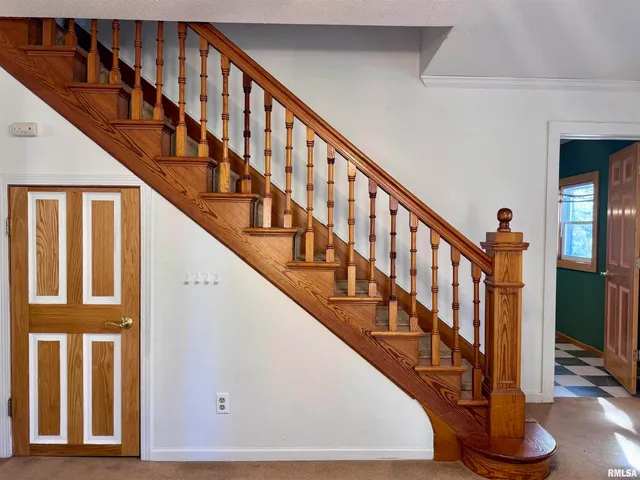 a view of staircase with lots of frames on wall and a window