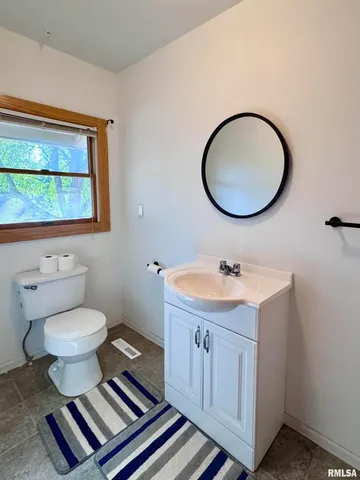 a bathroom with a toilet a sink and a mirror