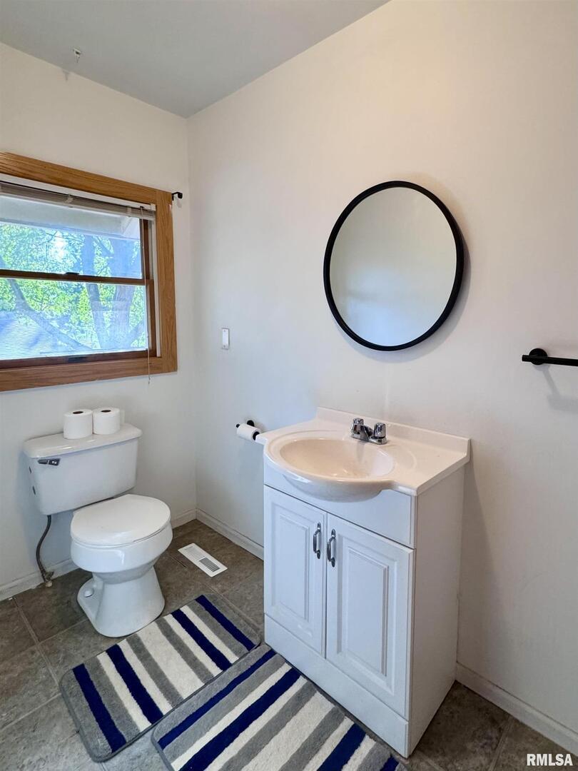 2711 North 2nd Street Clinton, IA 52732 - Photo 24 of 24 a bathroom with a toilet a sink and a mirror