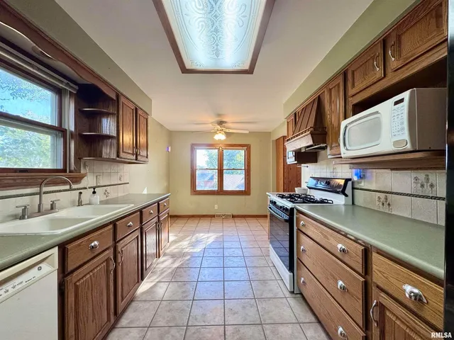 a kitchen with stainless steel appliances granite countertop a sink stove and cabinets
