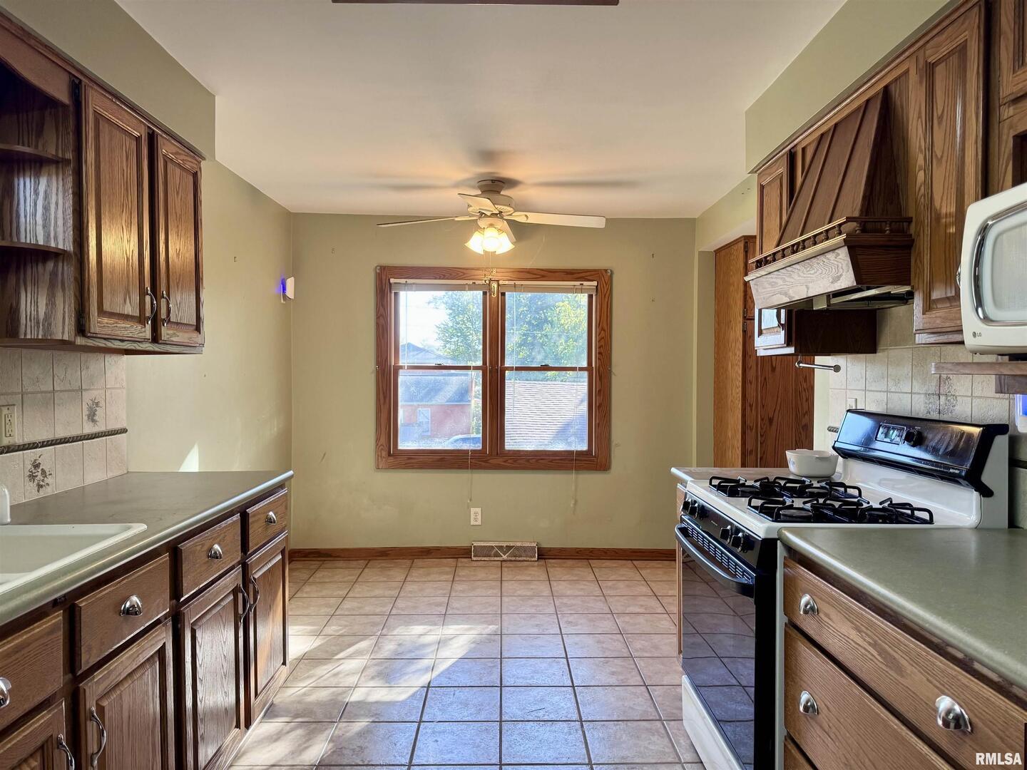 2711 North 2nd Street Clinton, IA 52732 - Photo 4 of 24 a kitchen that has a sink and a stove
