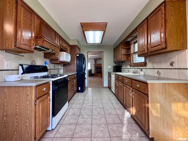 a large kitchen with stainless steel appliances granite countertop a stove a sink dishwasher and a refrigerator