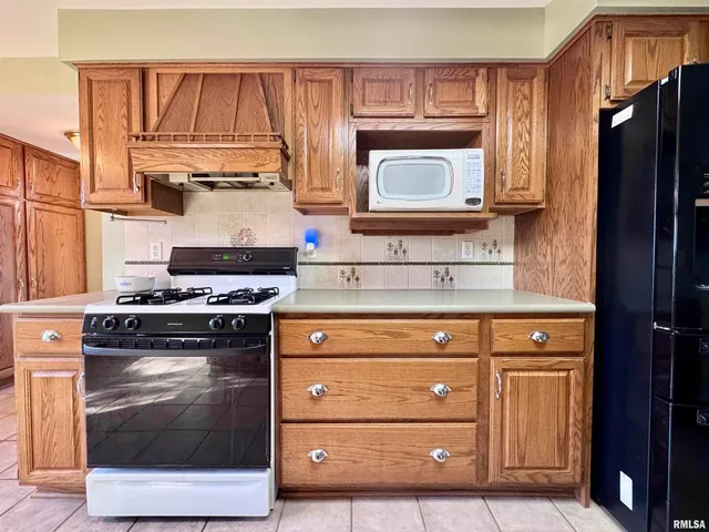 a kitchen with stainless steel appliances granite countertop a stove a microwave and a refrigerator