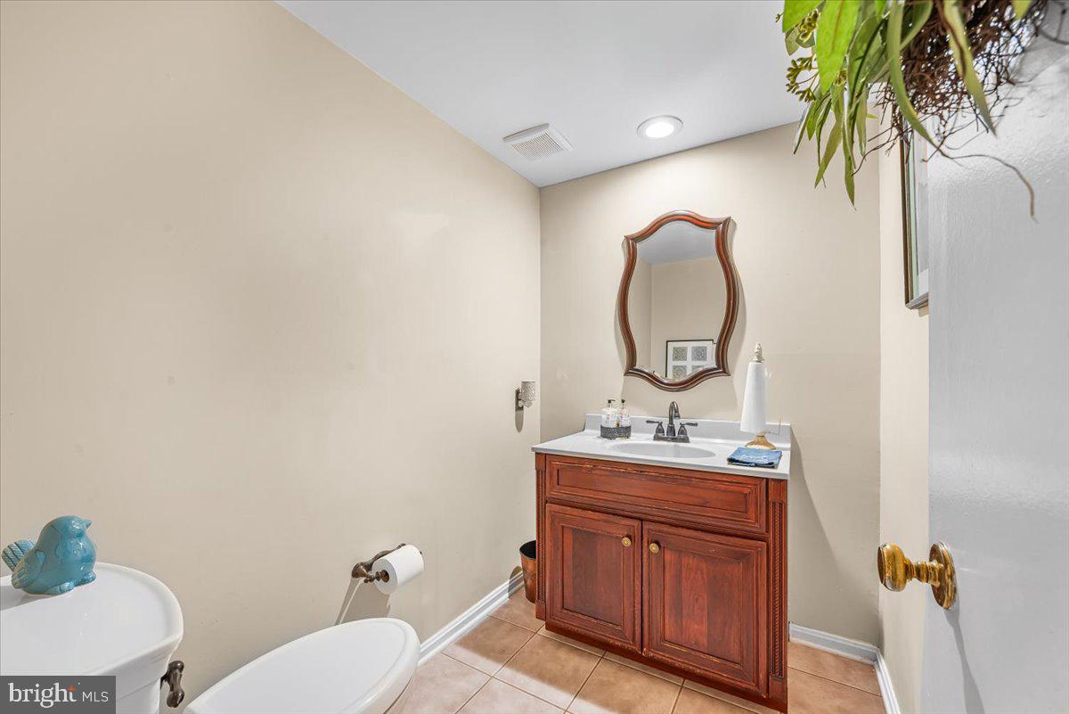 9809 Canal Road Gaithersburg, MD 20886 - Photo 19 of 50 a bathroom with a toilet sink vanity and mirror