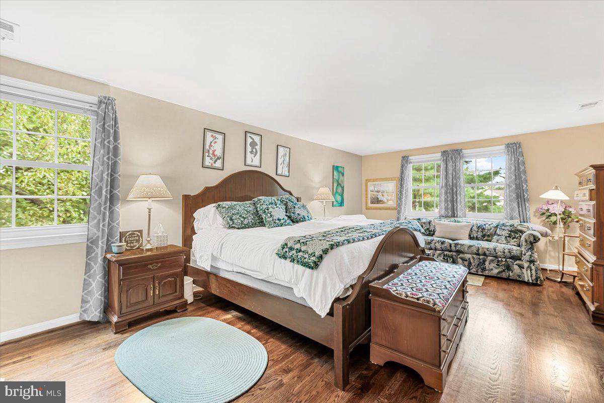 9809 Canal Road Gaithersburg, MD 20886 - Photo 22 of 50 a bedroom with a bed a table and chair with the large windows