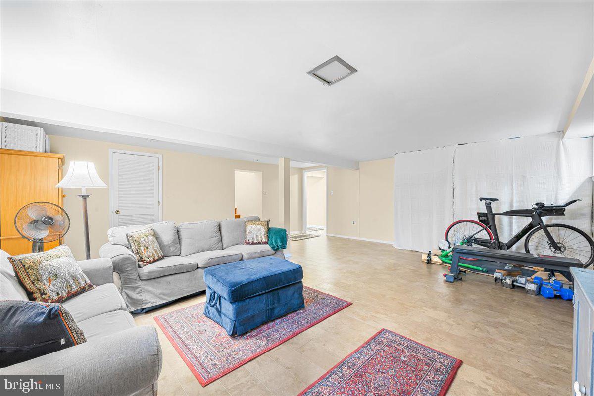 9809 Canal Road Gaithersburg, MD 20886 - Photo 38 of 50 a living room with furniture a rug and gym equipment
