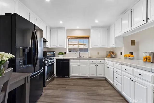 a kitchen with granite countertop white cabinets and stainless steel appliances
