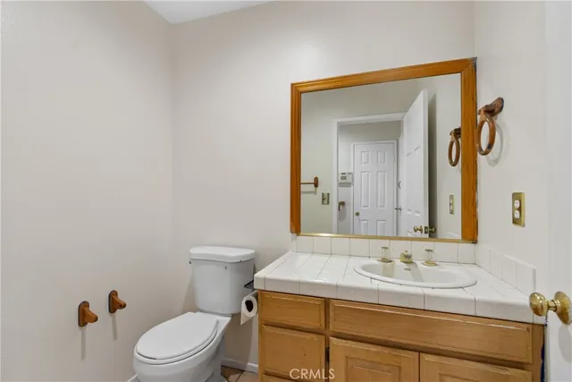 a bathroom with a granite countertop toilet sink and mirror