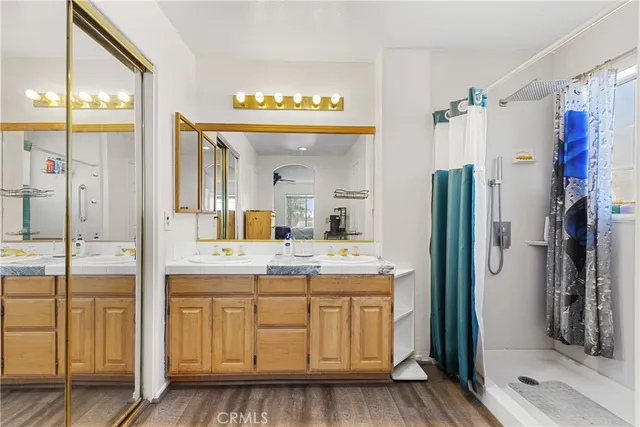 a spacious bathroom with a shower a mirror and a sink