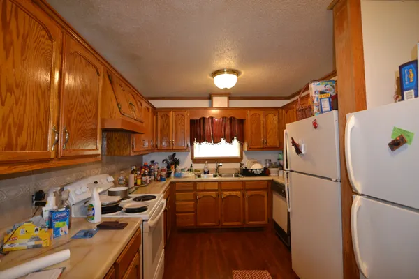 a kitchen with a refrigerator a sink and wooden cabinets