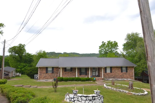a front view of a house with a garden and plants
