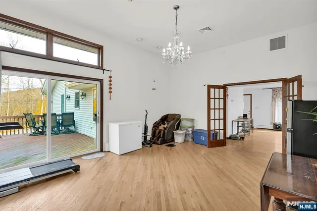 a view of a livingroom with furniture a fireplace wooden floor and windows