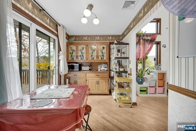 a dining room with wooden floor and large windows