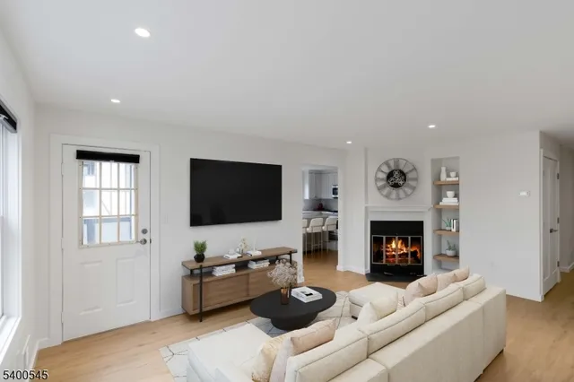 a living room with furniture a flat screen tv and a fireplace