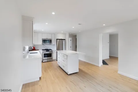a kitchen with cabinets and wooden floor
