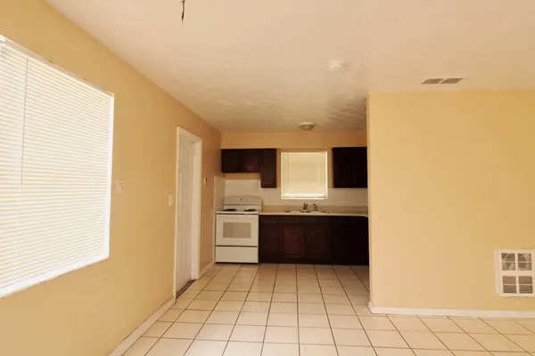 a view of kitchen with granite countertop cabinets and stove top oven