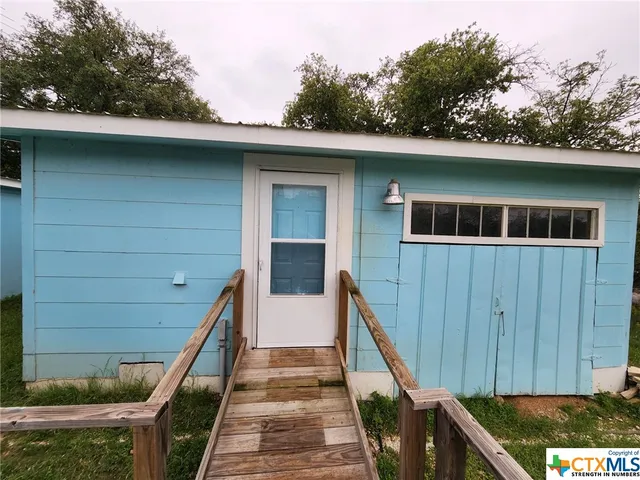 a view of a house with pool and wooden fence