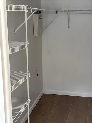 a view of empty room with wooden floor and cabinet