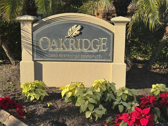 a front view of a house with a sign and flowers