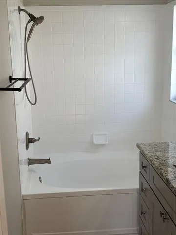 a bathroom with a granite countertop sink a toilet and shower