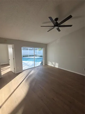 en empty room with windows and ceiling fan