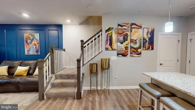 a hallway with wooden floor stairs and furniture