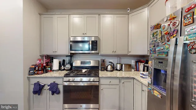 a kitchen with stainless steel appliances granite countertop a stove a sink and a refrigerator