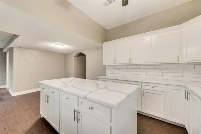 a kitchen with white cabinets appliances and sink